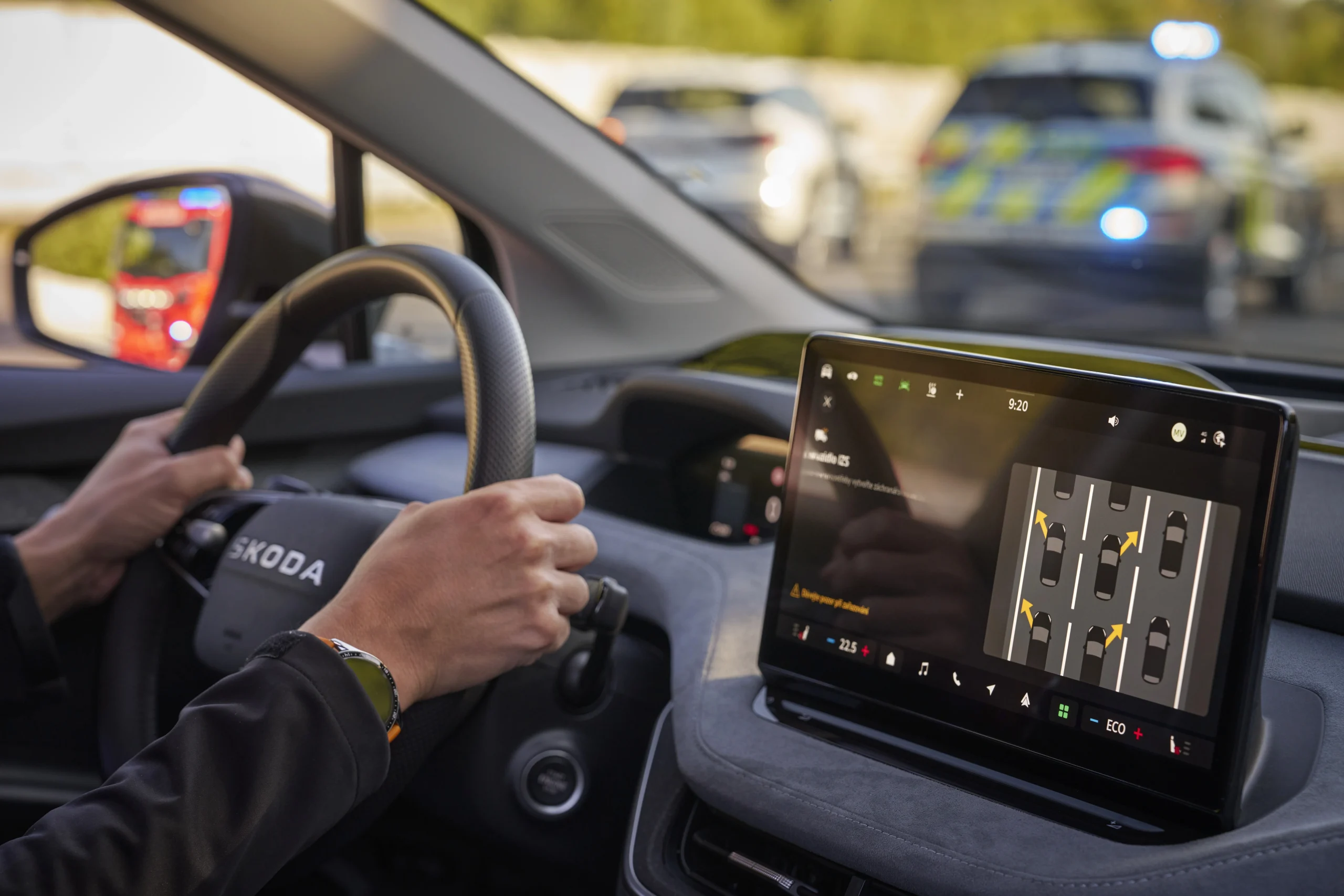 Displej infotainmentu Škoda zobrazující varování před vozidlem IZS a instrukce pro záchranářskou uličku