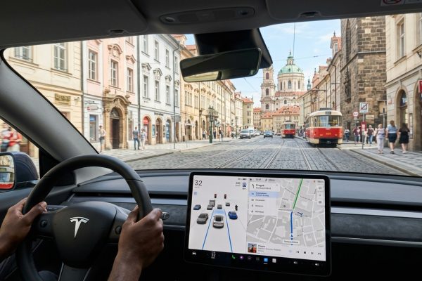 Tesla Model Y interiér s FSD displejem při jízdě Prahou