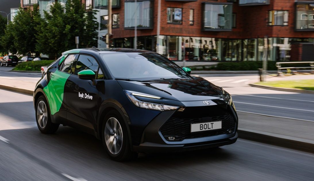 Toyota C-HR v polepu služby Bolt v pohybu na městské silnici