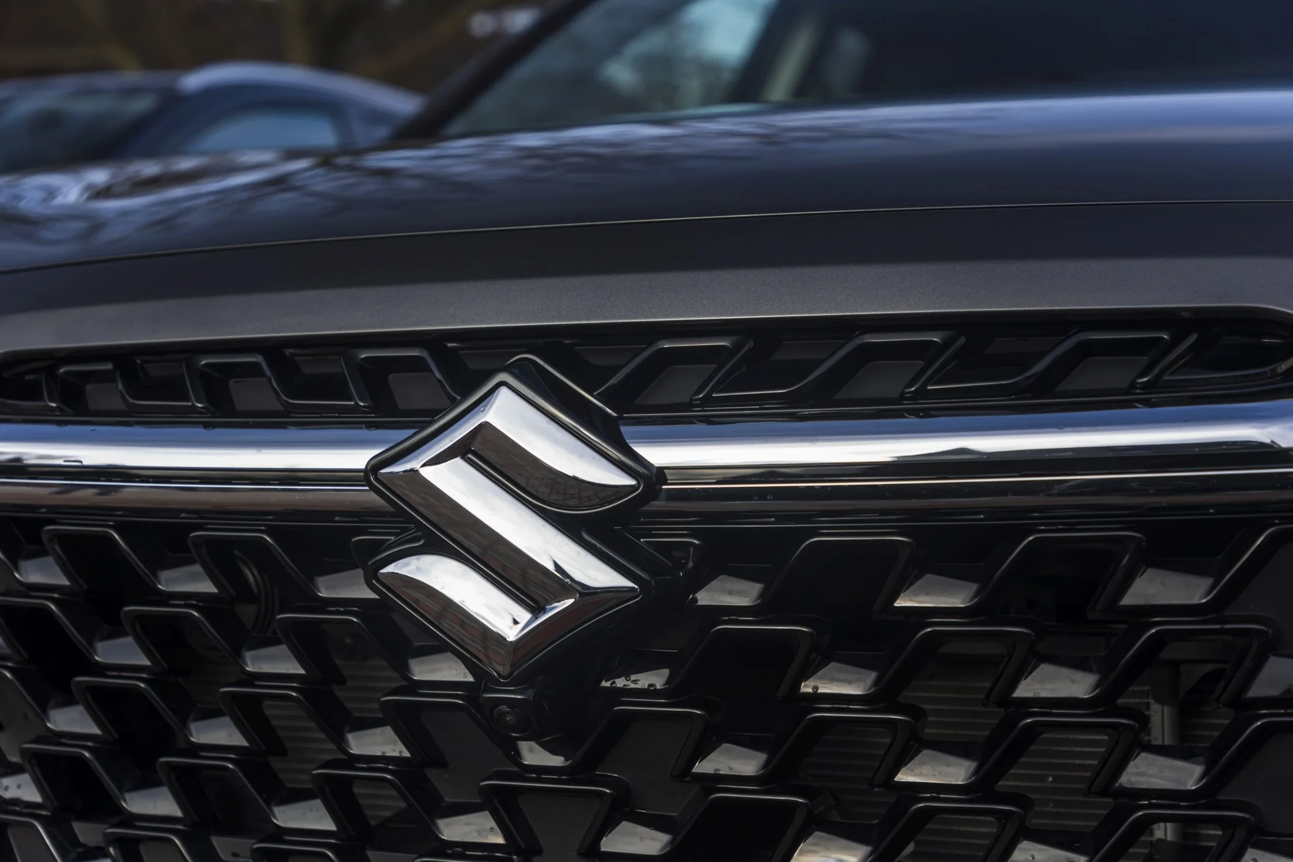 Detail emblému Suzuki na masce vozu