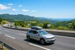 Rodinné SUV se střešním boxem na dálnici míří k moři