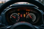 Přístrojový štít auta s rozsvícenými výstražnými kontrolkami - check engine, olej, baterie, ABS a TPMS