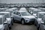 Jedno nové SUV obklopené dalšími na odstavném parkovišti dealera, čekající na prodej