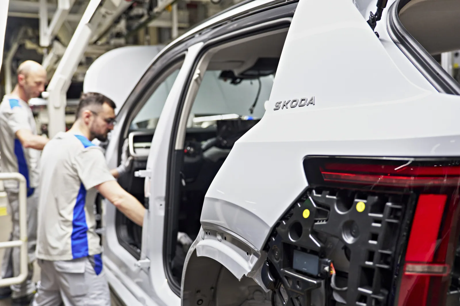 Pracovníci kompletují karoserii Škody Epiq na lince ve VW Navarra