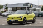 Volvo EX30 v žluté barvě zaparkované na parkovišti u supermarketu