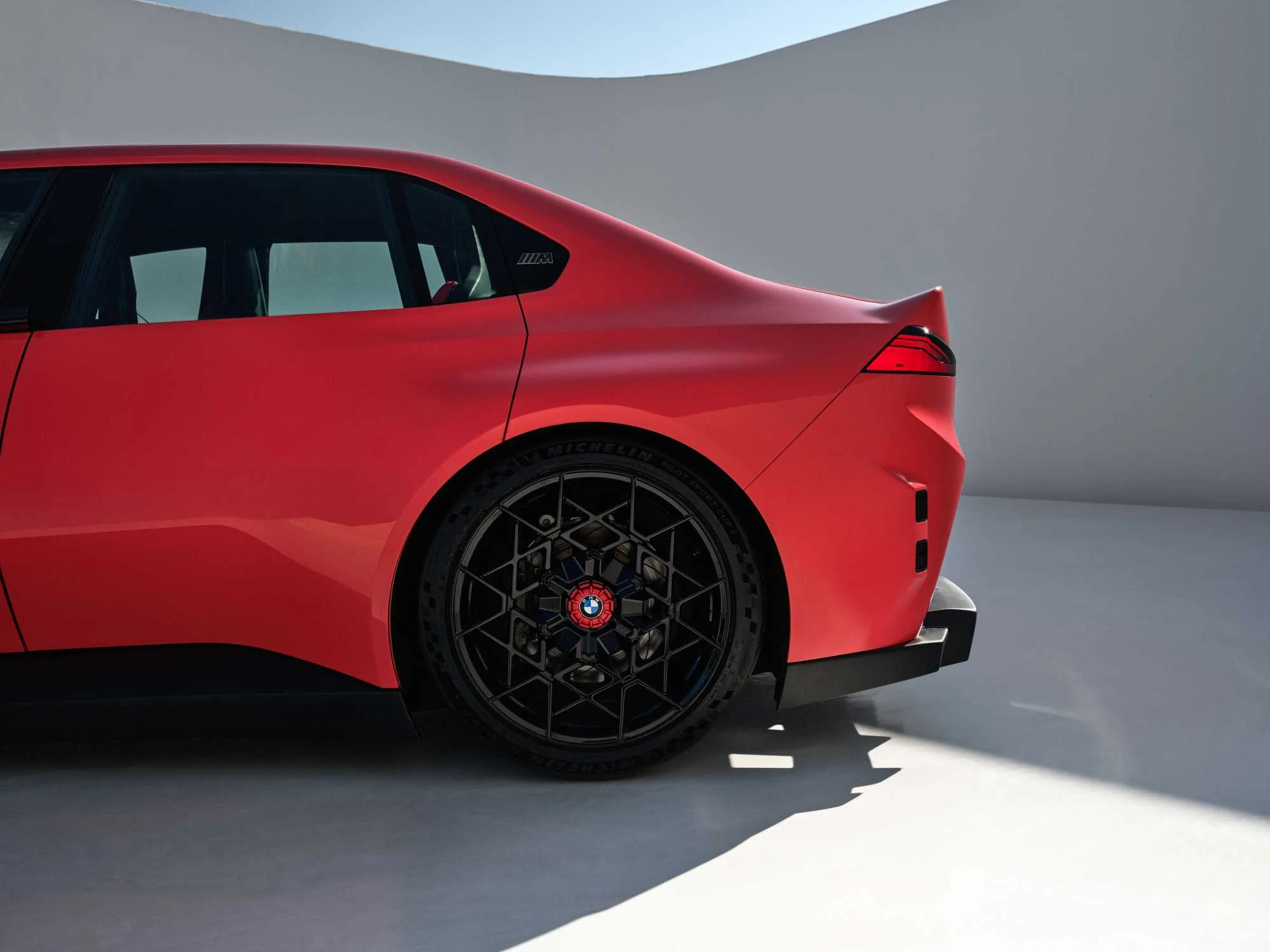 Zadní část konceptu BMW M Concept Neue Klasse s ducktail spoilerem a kolem s modrou centrální maticí
