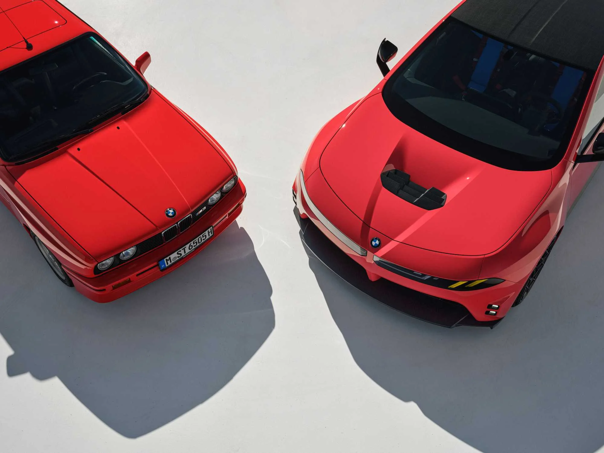 Pohled shora na přední části BMW M3 E30 a konceptu BMW M Concept Neue Klasse