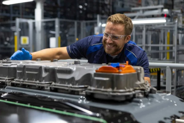 Montáž vysokonapěťové baterie pro BMW iX5 v továrně BMW Group ve Woodruffu, pracovník u bateriového paketu s řídicí jednotkou Energy Master