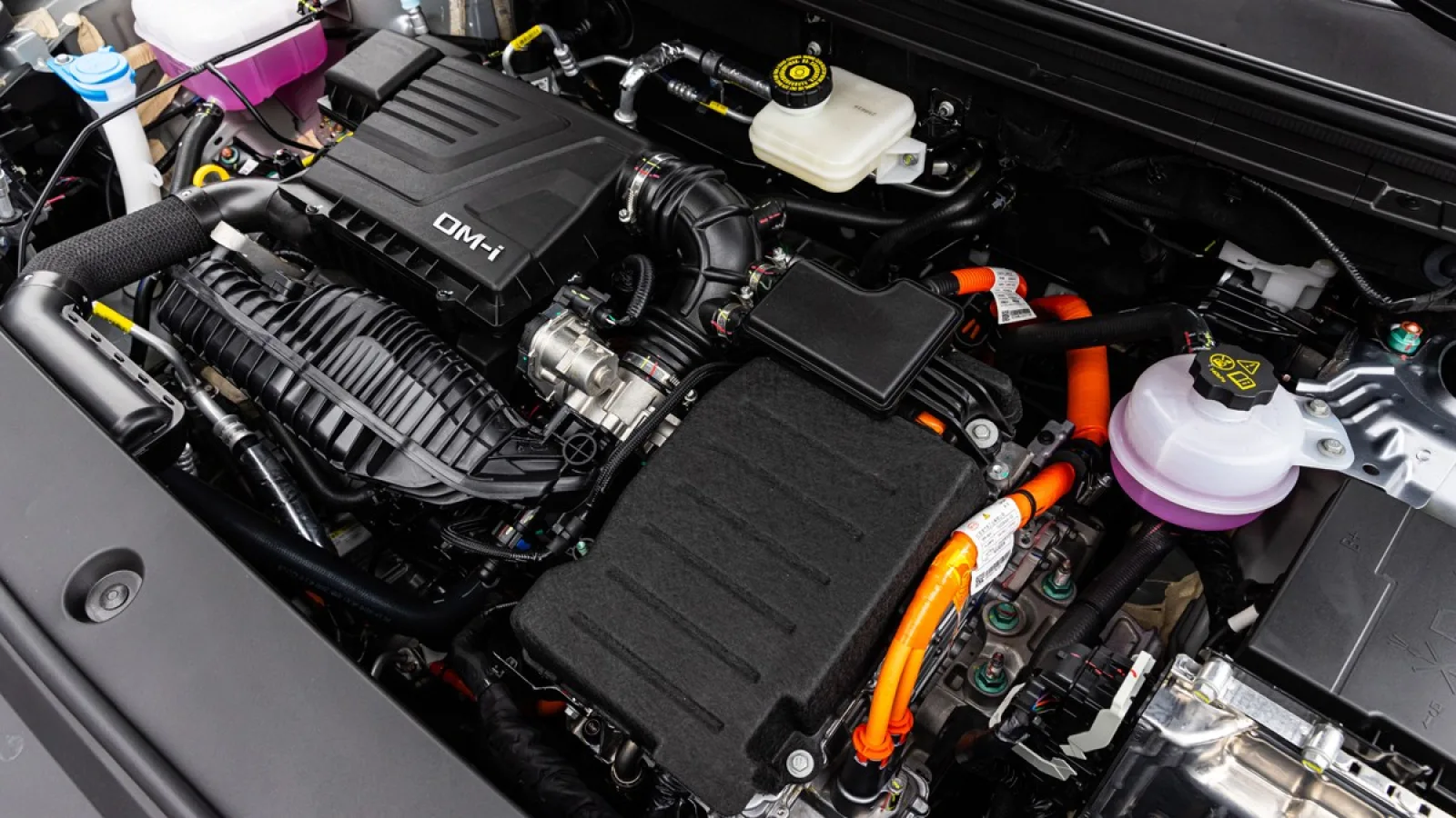 Motorový prostor BYD Sealion 5 DM-i s krytem DM-i a oranžovými vysokonapěťovými kabely