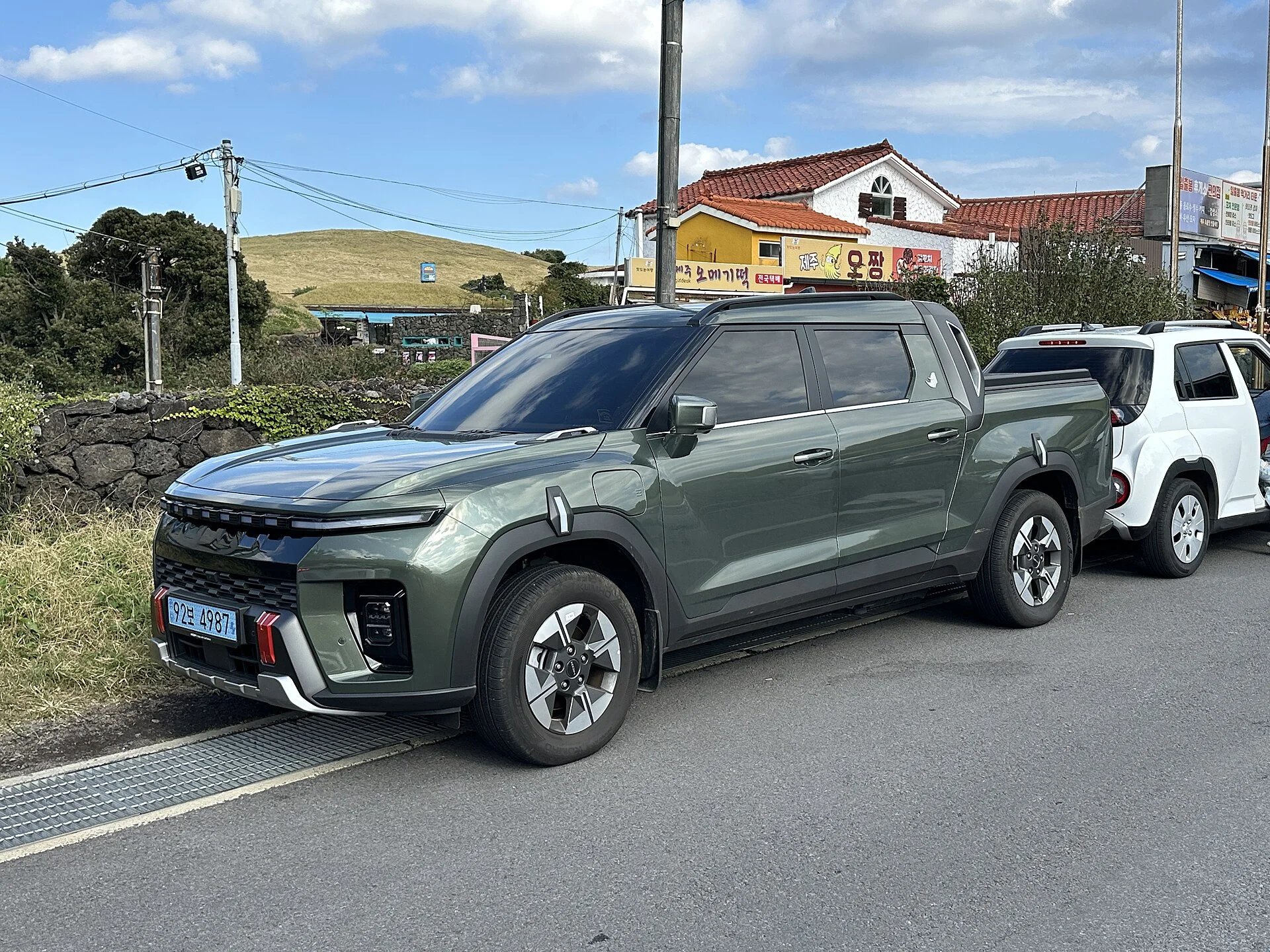 Elektrický pick-up KGM Musso EV v zelené barvě, přední tříčtvrteční pohled