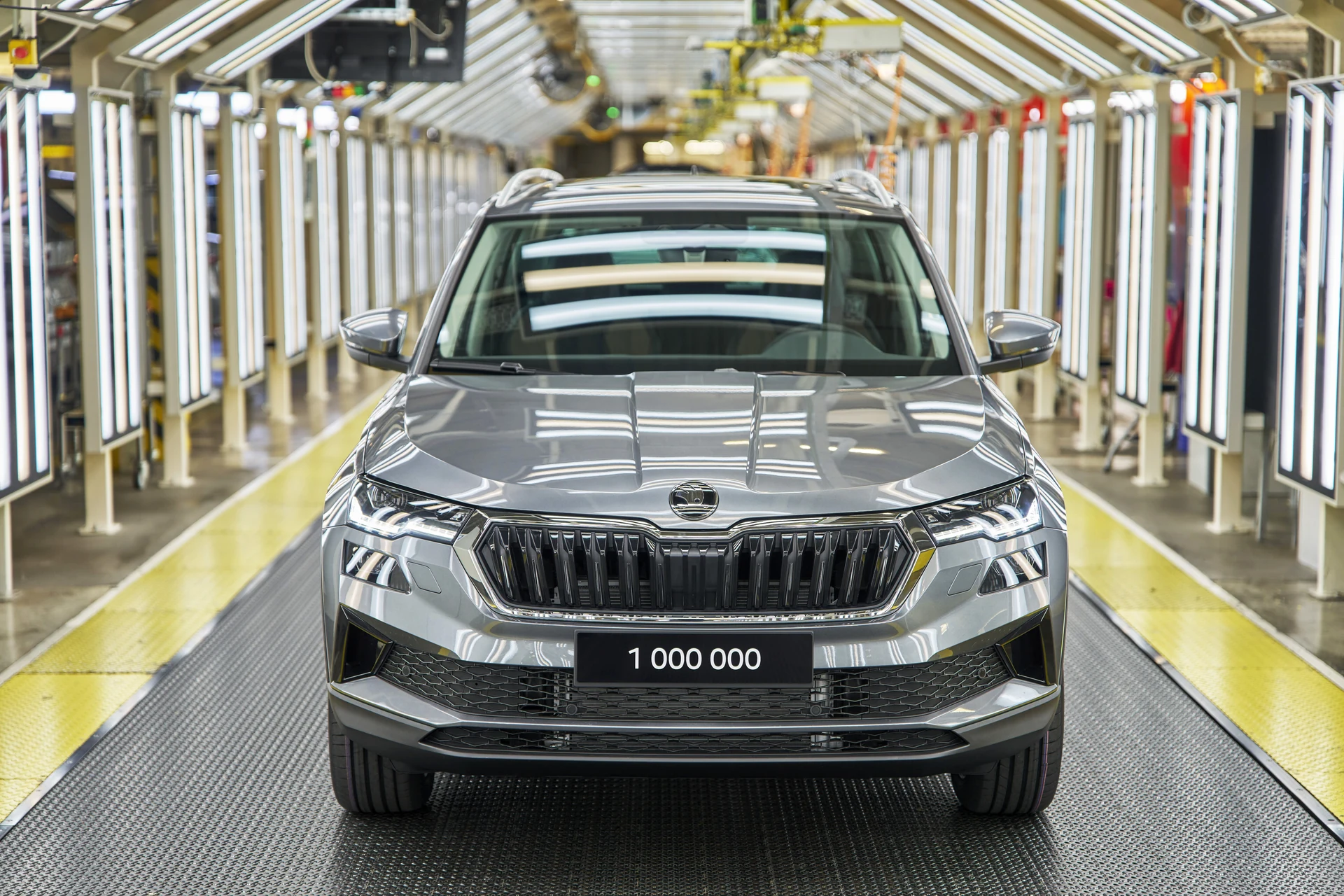 Miliontý Škoda Karoq v šedé barvě Graphite na výrobní lince v Kvasinách, pohled zepředu s tabulkou 1 000 000