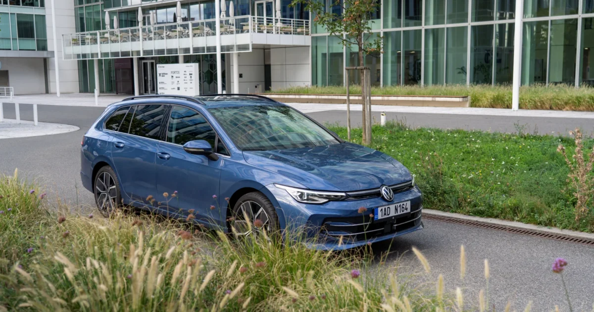 Modrý Volkswagen Golf Variant zepředu z boku před prosklenou budovou