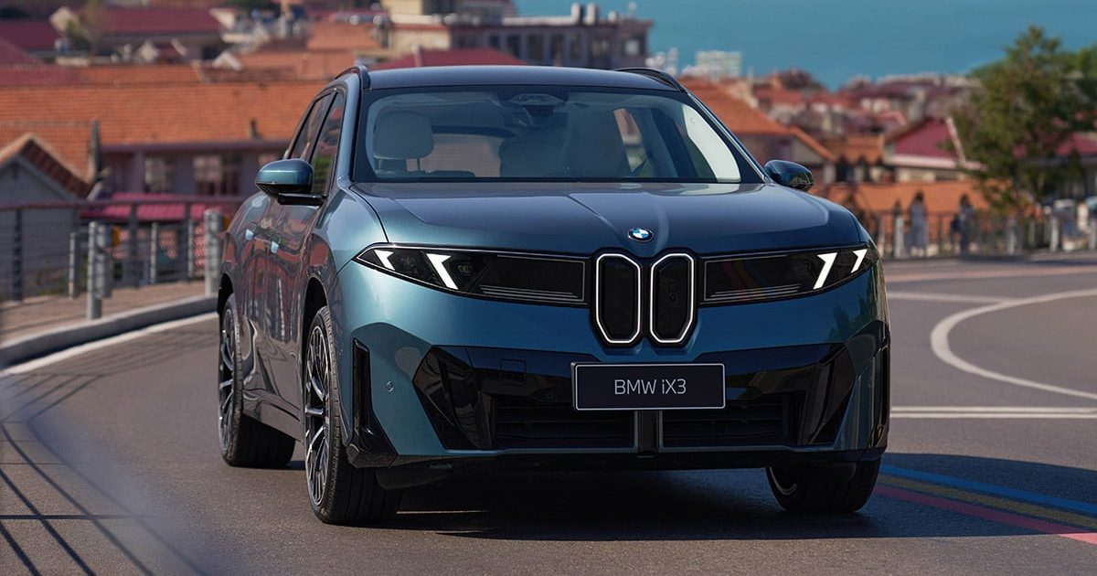 Modré BMW iX3 L s dlouhým rozvorem v čelním pohledu na pobřežní silnici