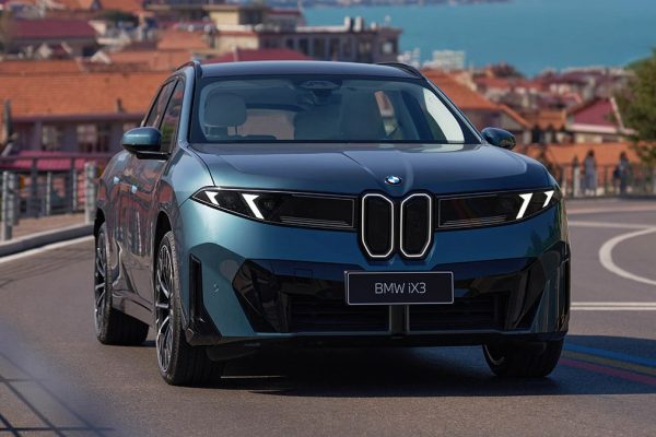 Modré BMW iX3 L s dlouhým rozvorem v čelním pohledu na pobřežní silnici