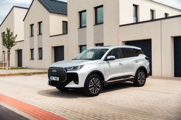 Stříbrné SUV Chery Tiggo 7 HEV zaparkované před budovou