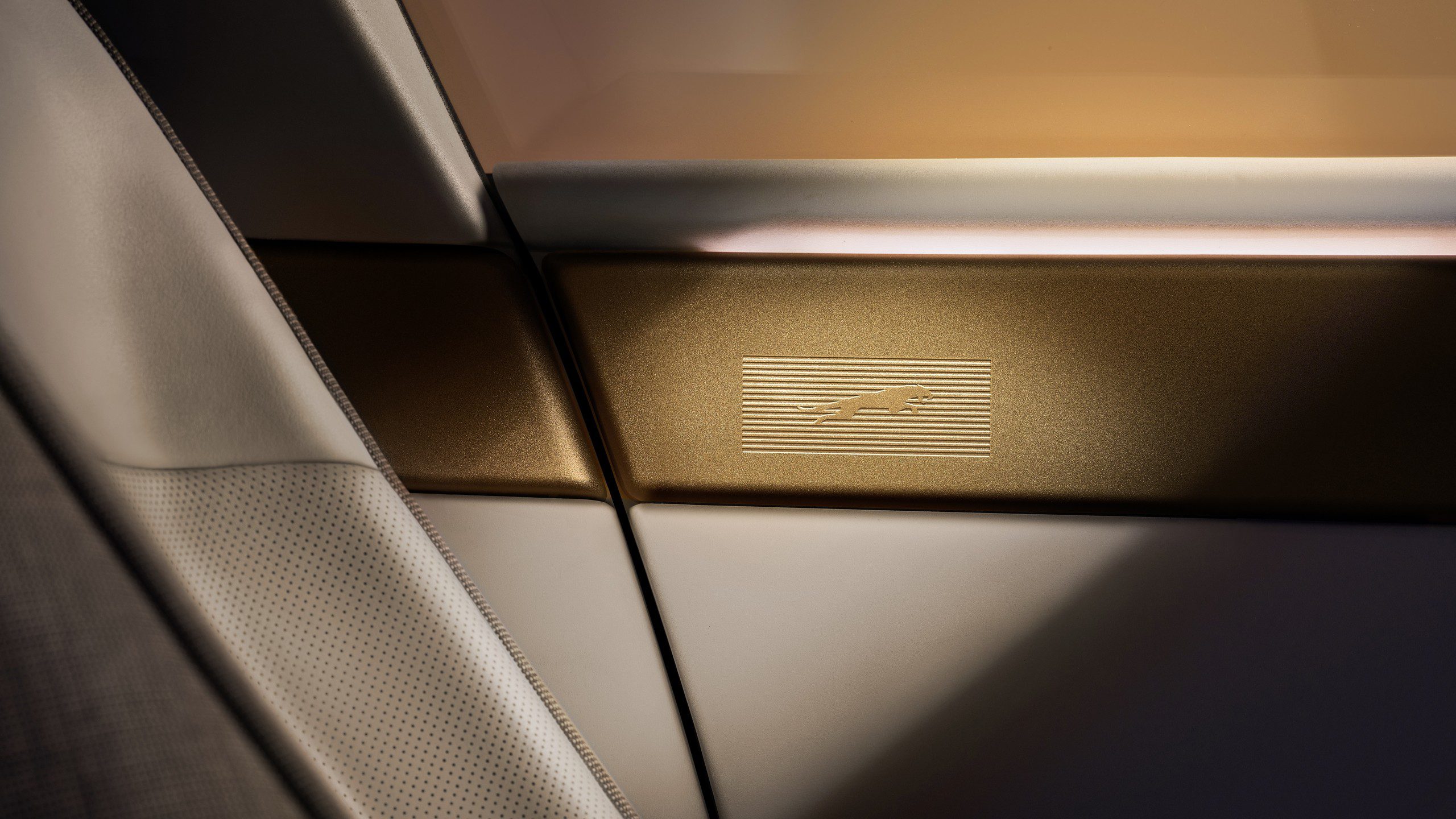 Detail interiéru Jaguaru Type 01 s mosazným lemem a vyraženým motivem jaguára ve skoku