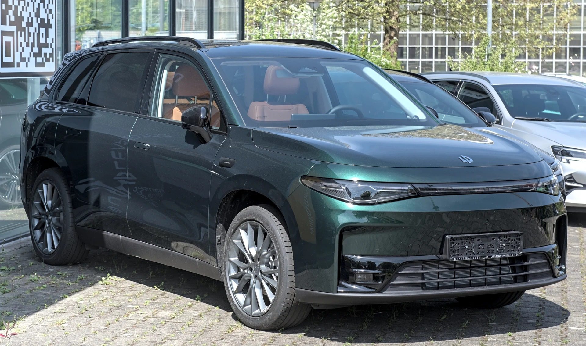 Tmavě zelené SUV Leapmotor C10 zaparkované před budovou