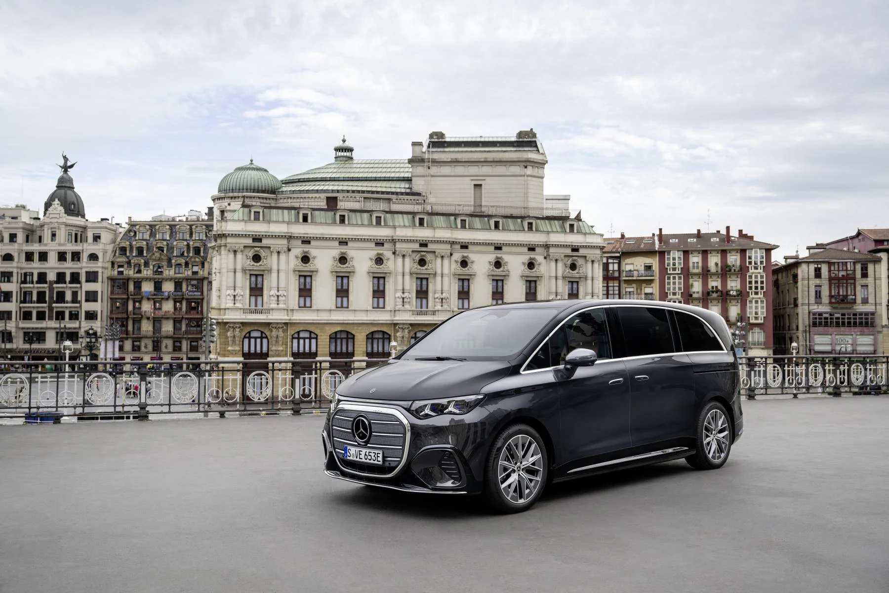 Tmavý Mercedes-Benz VLE zaparkovaný na náměstí před historickou budovou