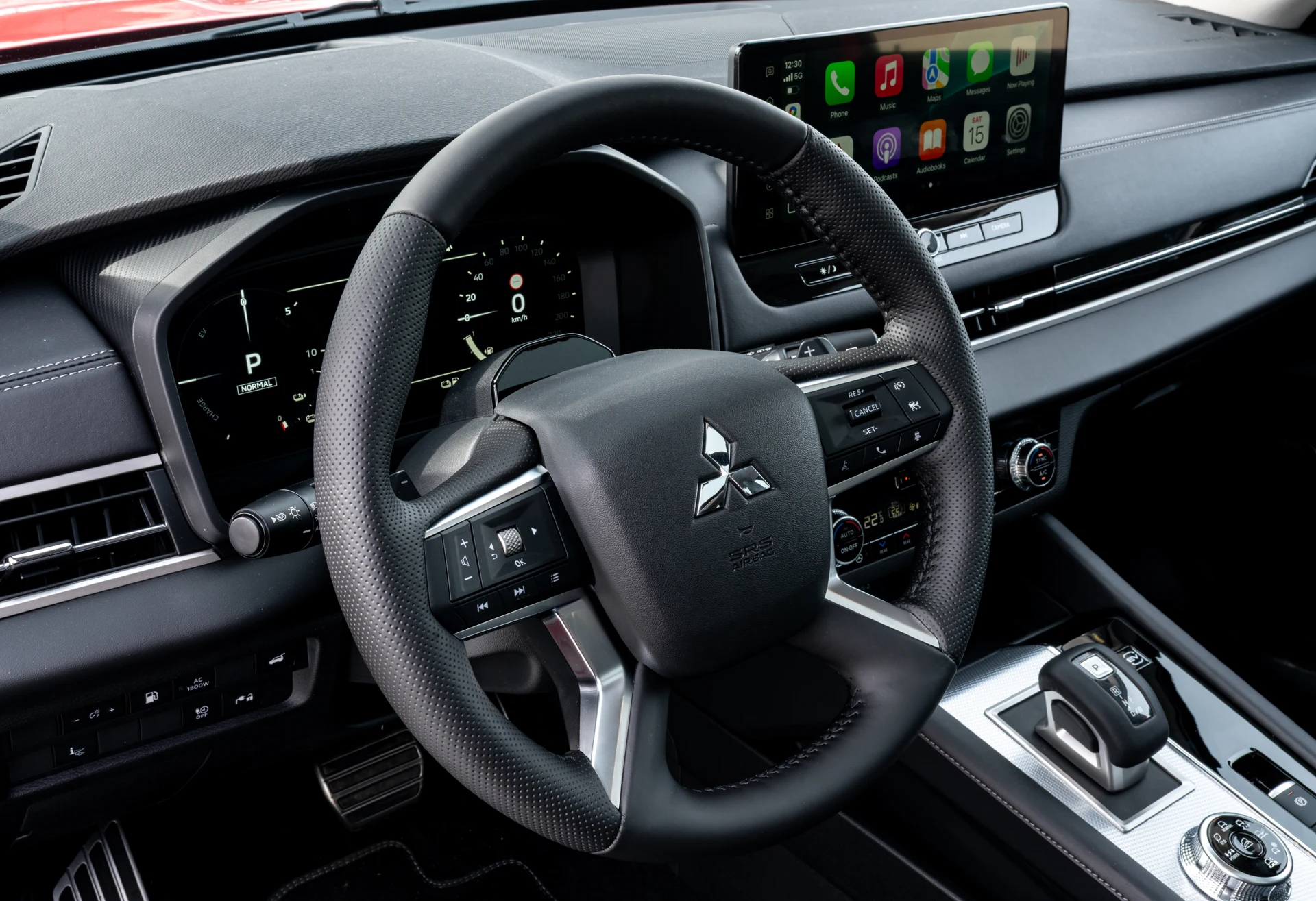 Interiér Mitsubishi Outlander PHEV s fyzickými tlačítky klimatizace a digitálním štítem