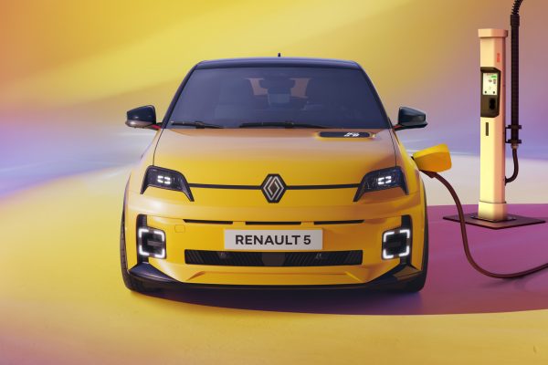 Žlutý Renault 5 E-Tech Electric zepředu připojený k rychlonabíjecí stanici