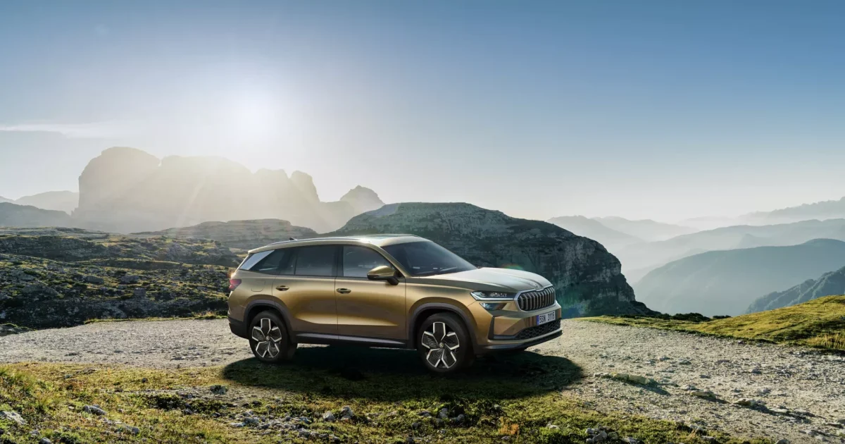 Zlatá Škoda Kodiaq druhé generace v předním tříčtvrtečním pohledu v horské krajině