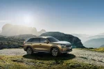 Zlatá Škoda Kodiaq druhé generace v předním tříčtvrtečním pohledu v horské krajině