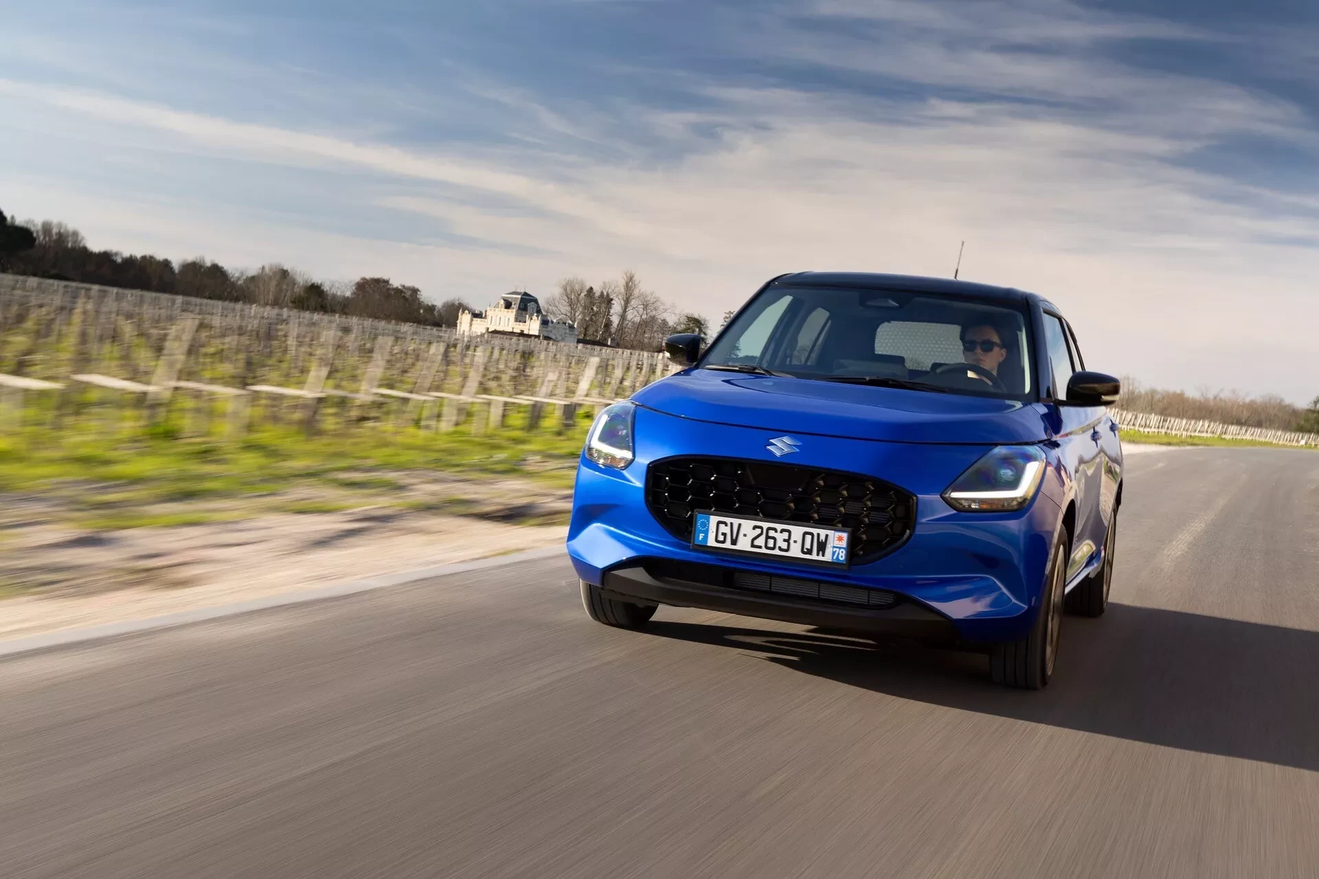 Modrý Suzuki Swift 2024 při jízdě po silnici