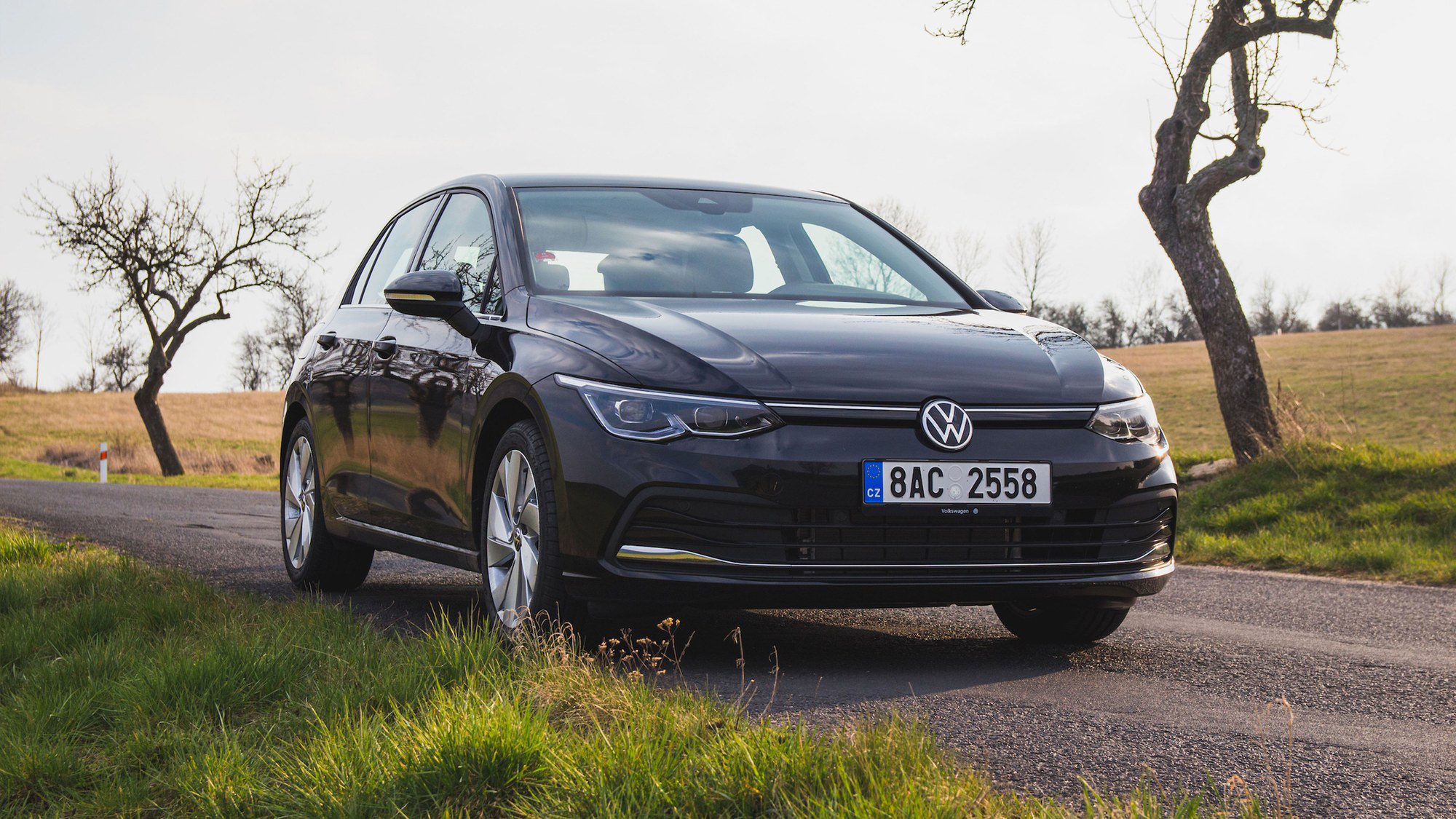 Černý Volkswagen Golf osmé generace zepředu na polní silnici
