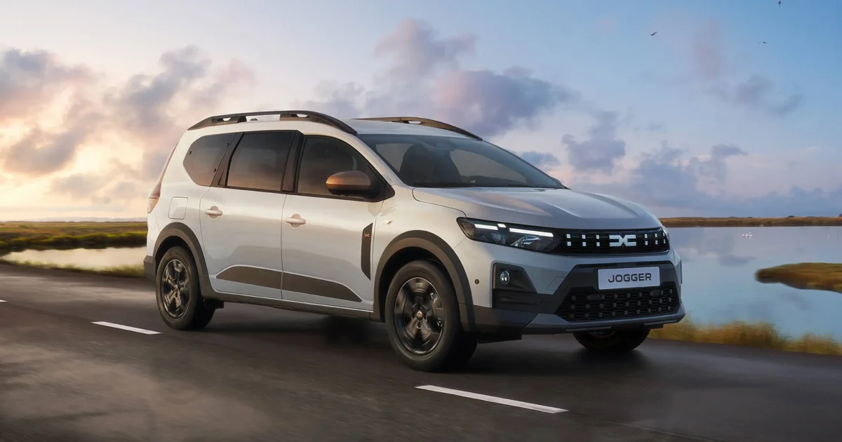 Bílá Dacia Jogger 2026 jedoucí po silnici u vody