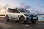 Bílá Dacia Jogger 2026 jedoucí po silnici u vody