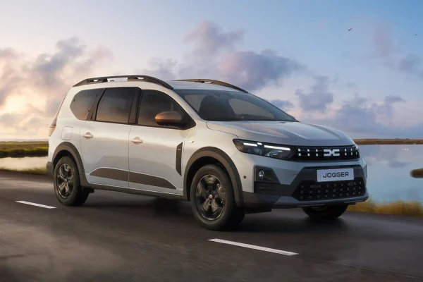 Bílá Dacia Jogger 2026 jedoucí po silnici u vody
