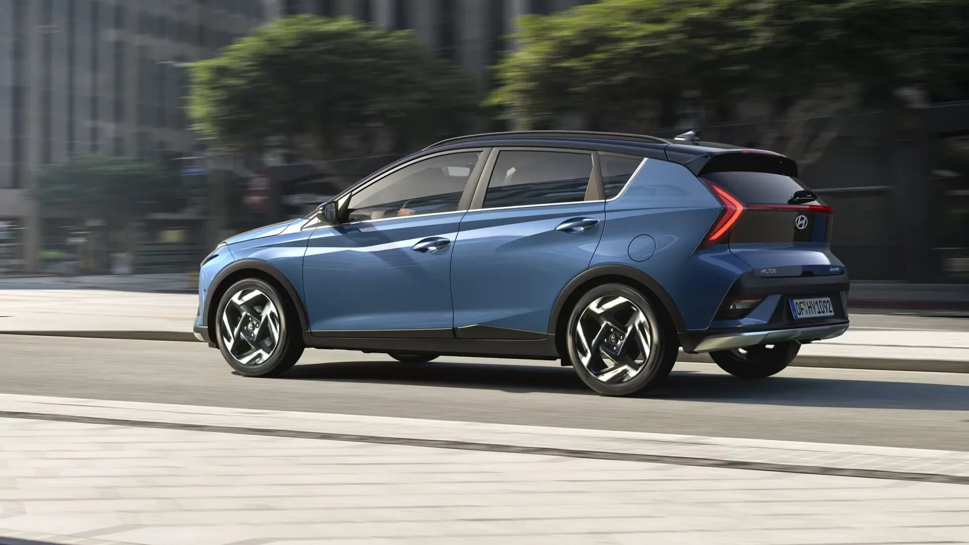 Současný Hyundai Bayon v modré barvě, boční pohled na jedoucí vůz ve městě