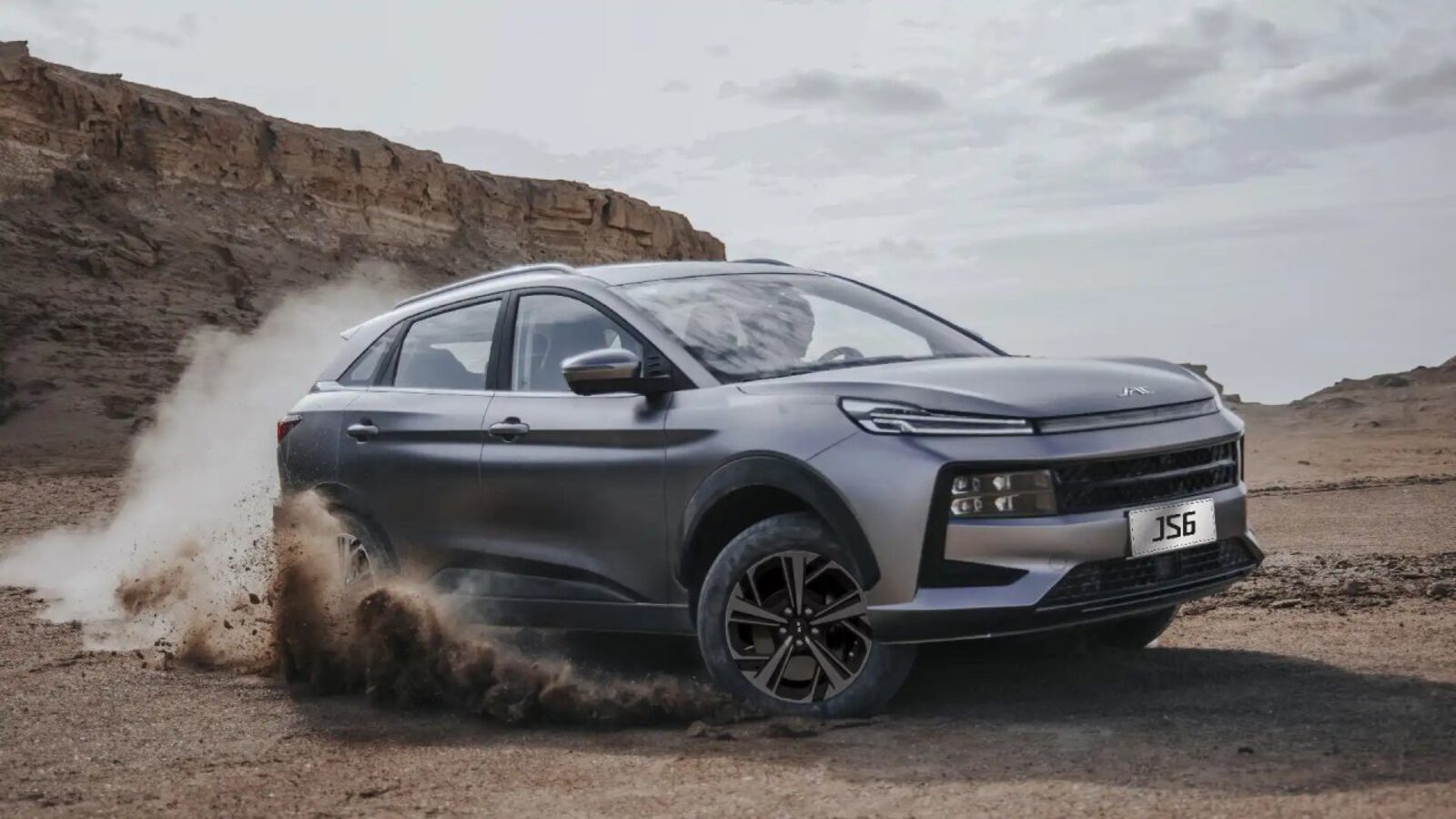 Šedé SUV JAC JS6 v terénu, celé auto zepředu z boku
