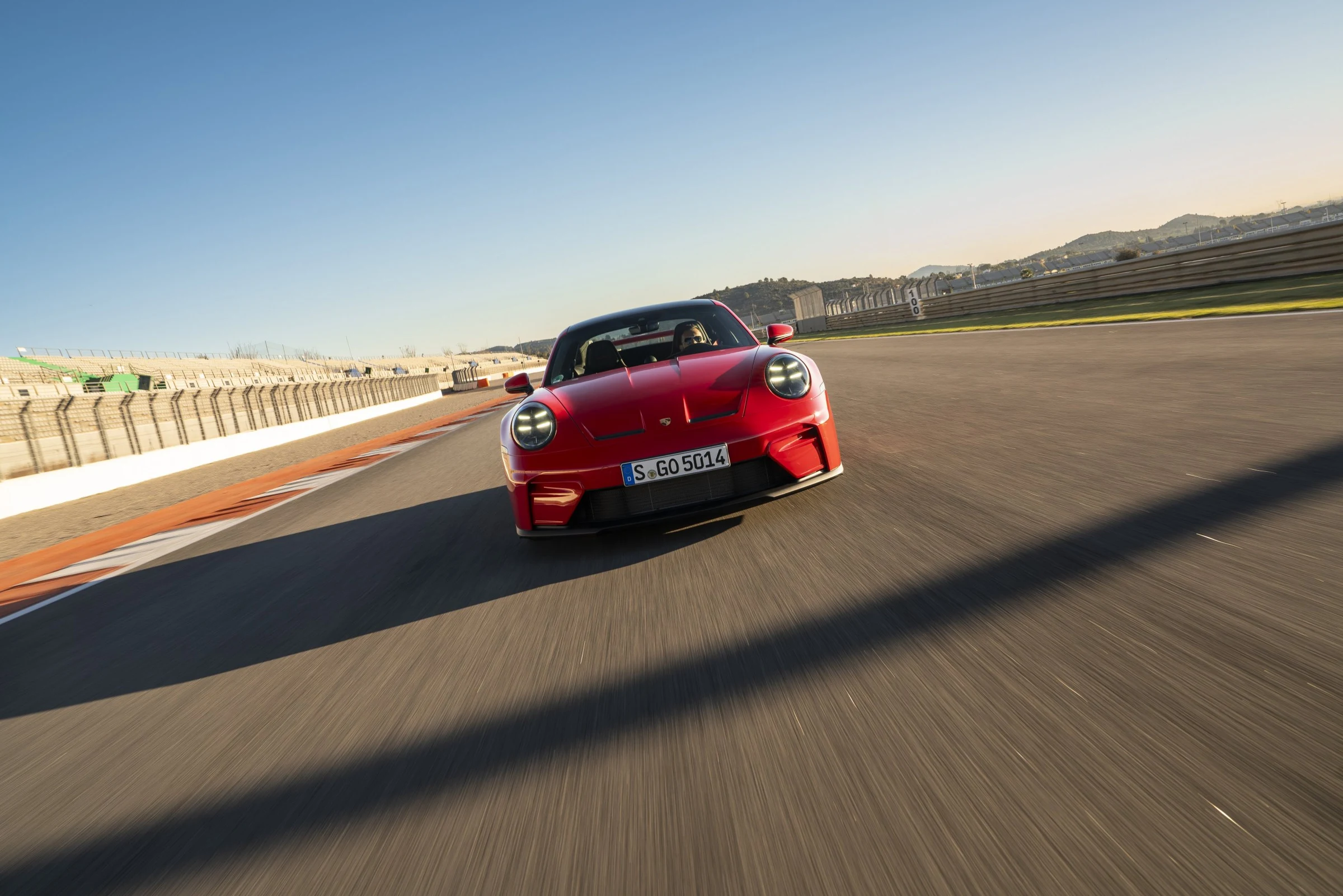 Červené Porsche 911 GT3 992.2 v jízdě na závodním okruhu