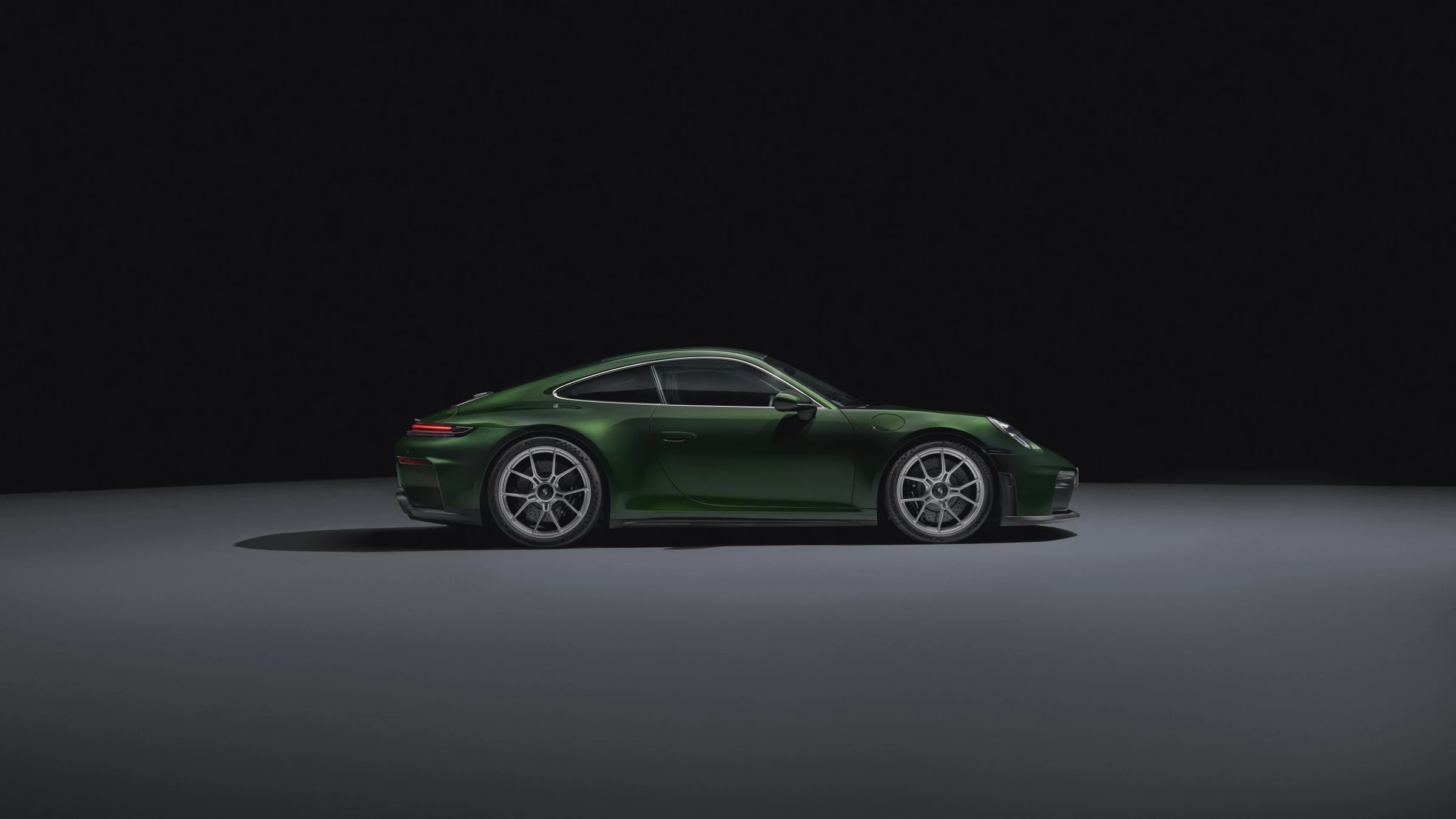 Porsche 911 GT3 s paketem Touring 992.2 v zelené barvě z boku, bez pevného zadního křídla