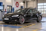 AI ilustrace Tesly Model S první generace na stanici technické kontroly STK