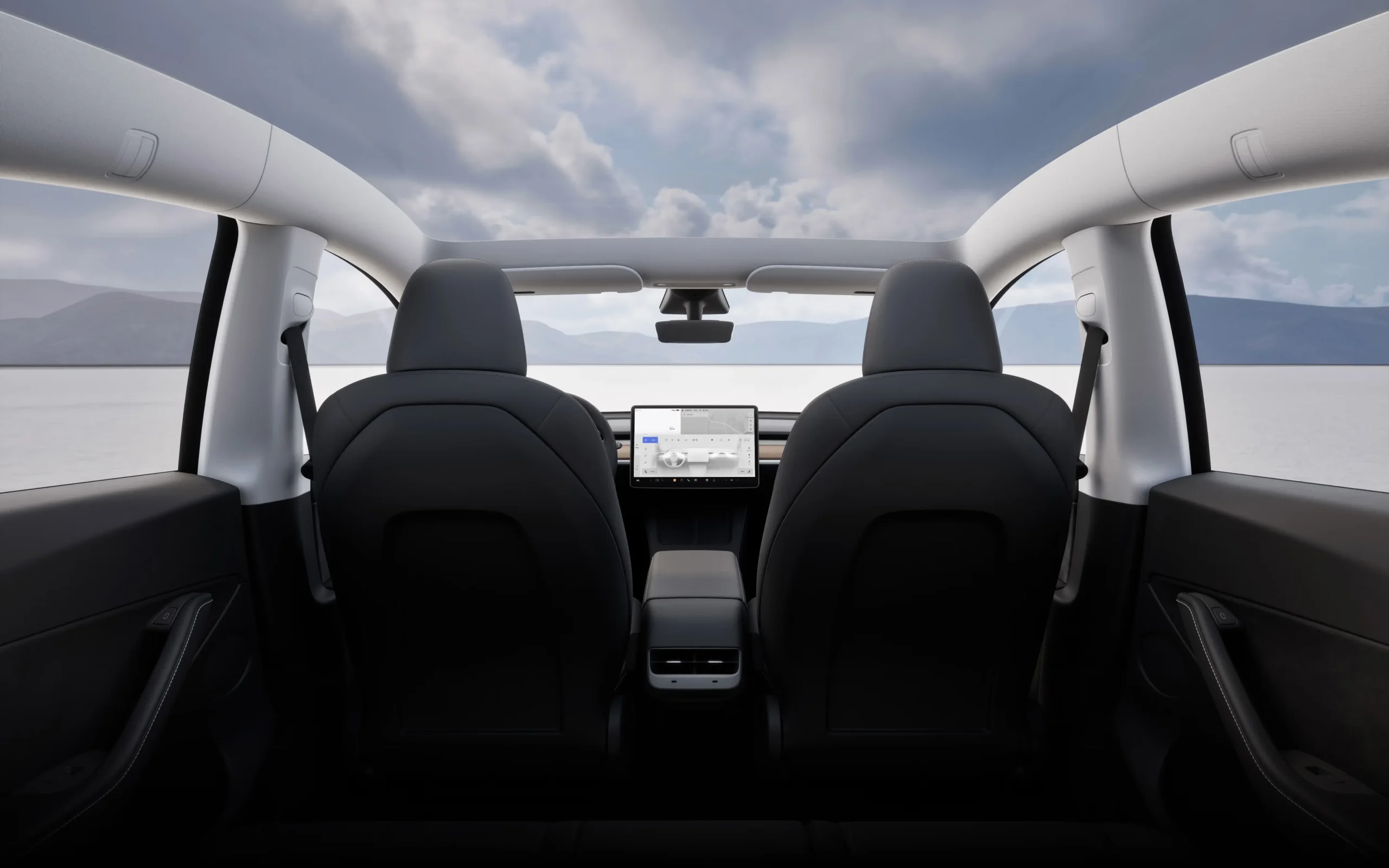 Interiér Tesla Model Y, pohled ze zadních sedadel na středový displej