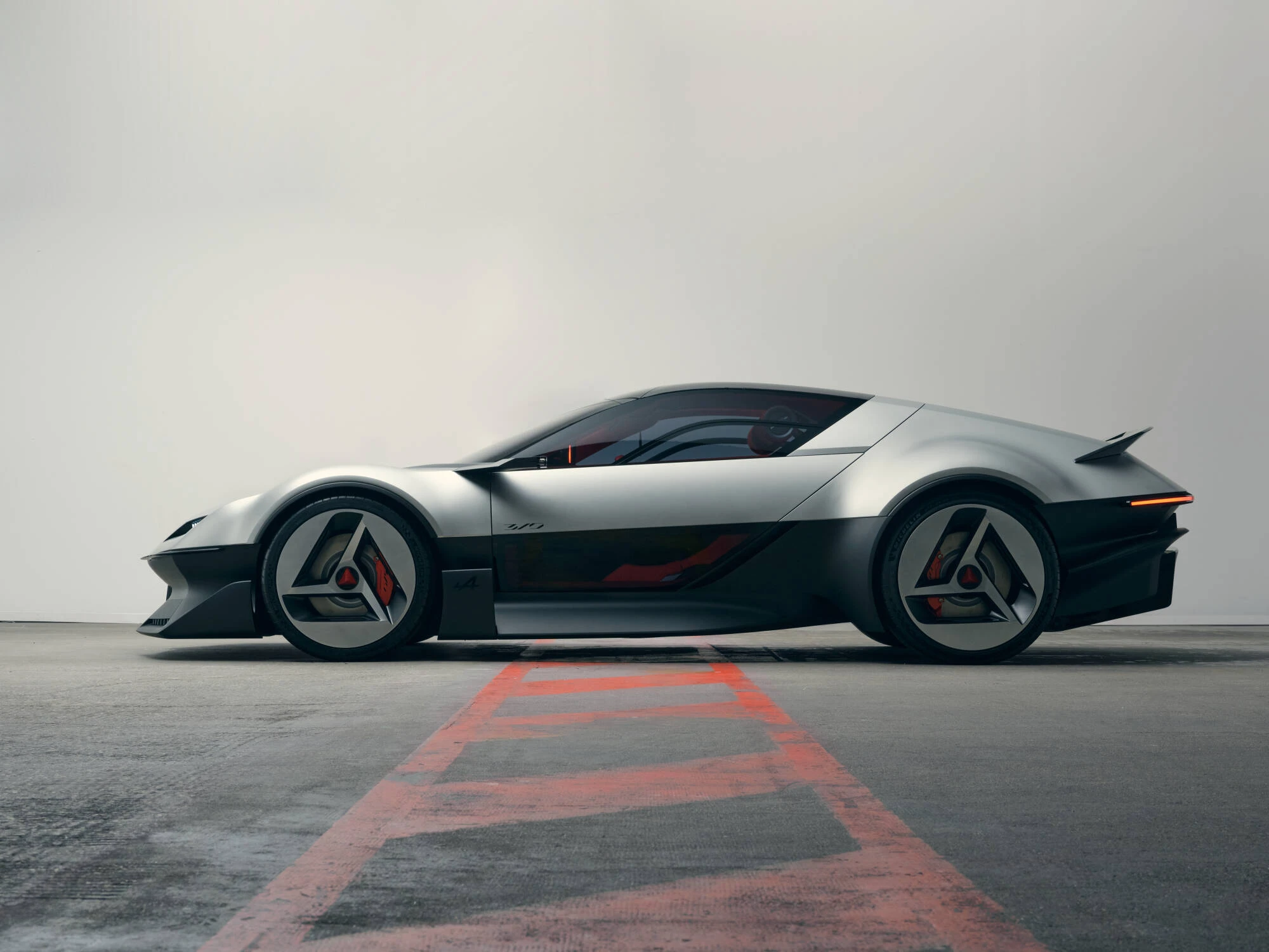 Boční profil konceptu Alpine A310 Vision se stříbrnou karoserií a trojúhelníkovými prvky kol