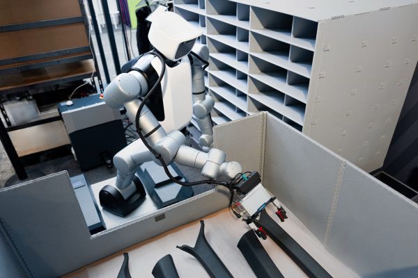 Humanoidní robot manipuluje s dílem v laboratorním logistickém pracovišti