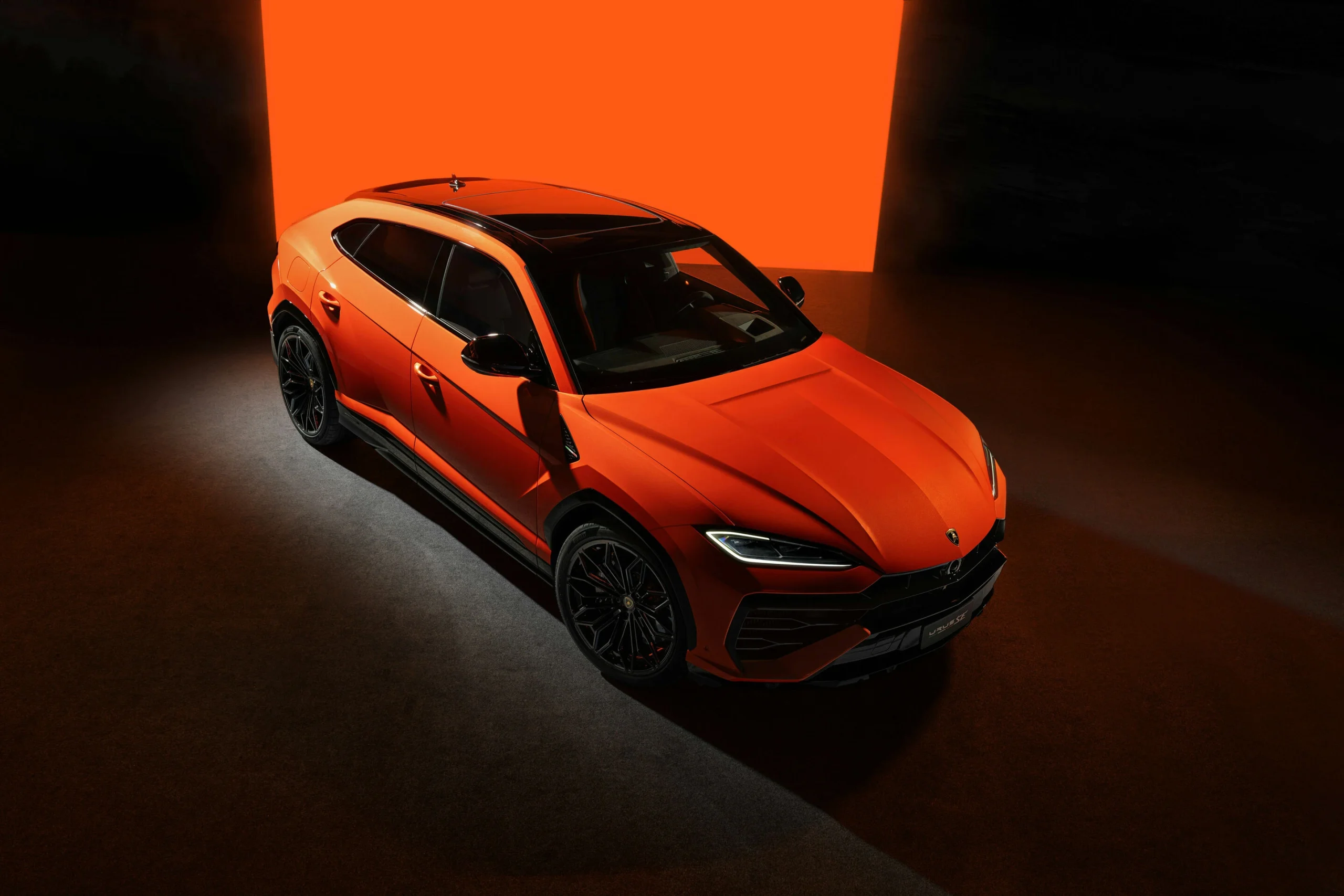 Lamborghini Urus SE v oranžovém laku z vyvýšeného předního tříčtvrtečního pohledu