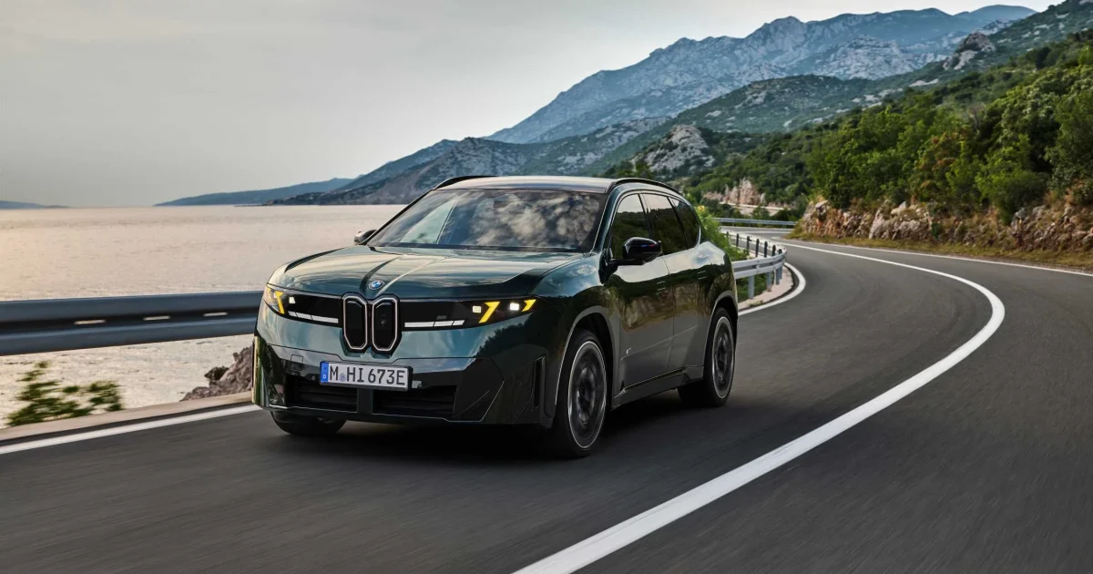 BMW iX3 M60 xDrive v zeleném laku při jízdě po pobřežní silnici