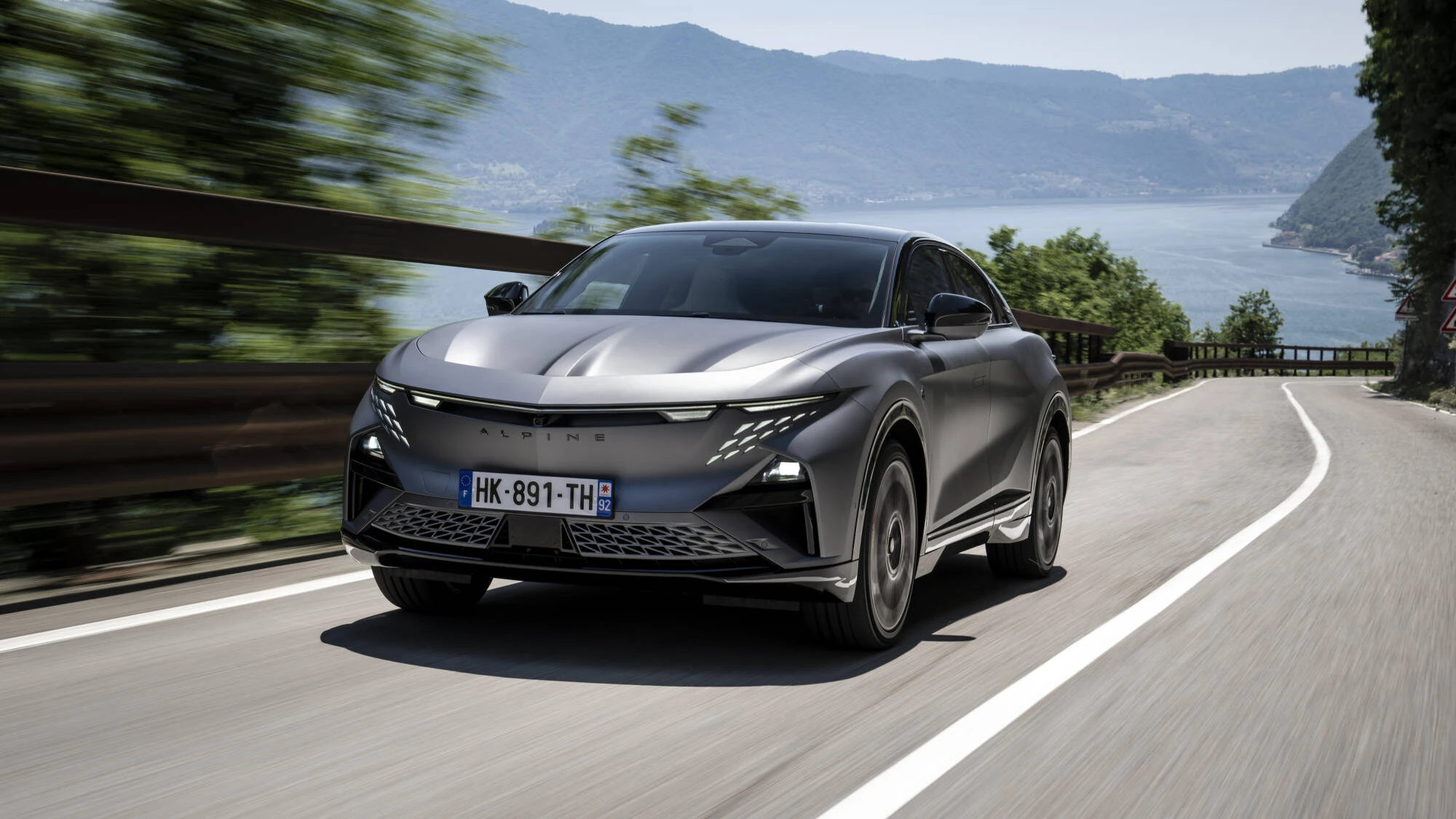 Šedá Alpine A390 GTS na silnici u jezera