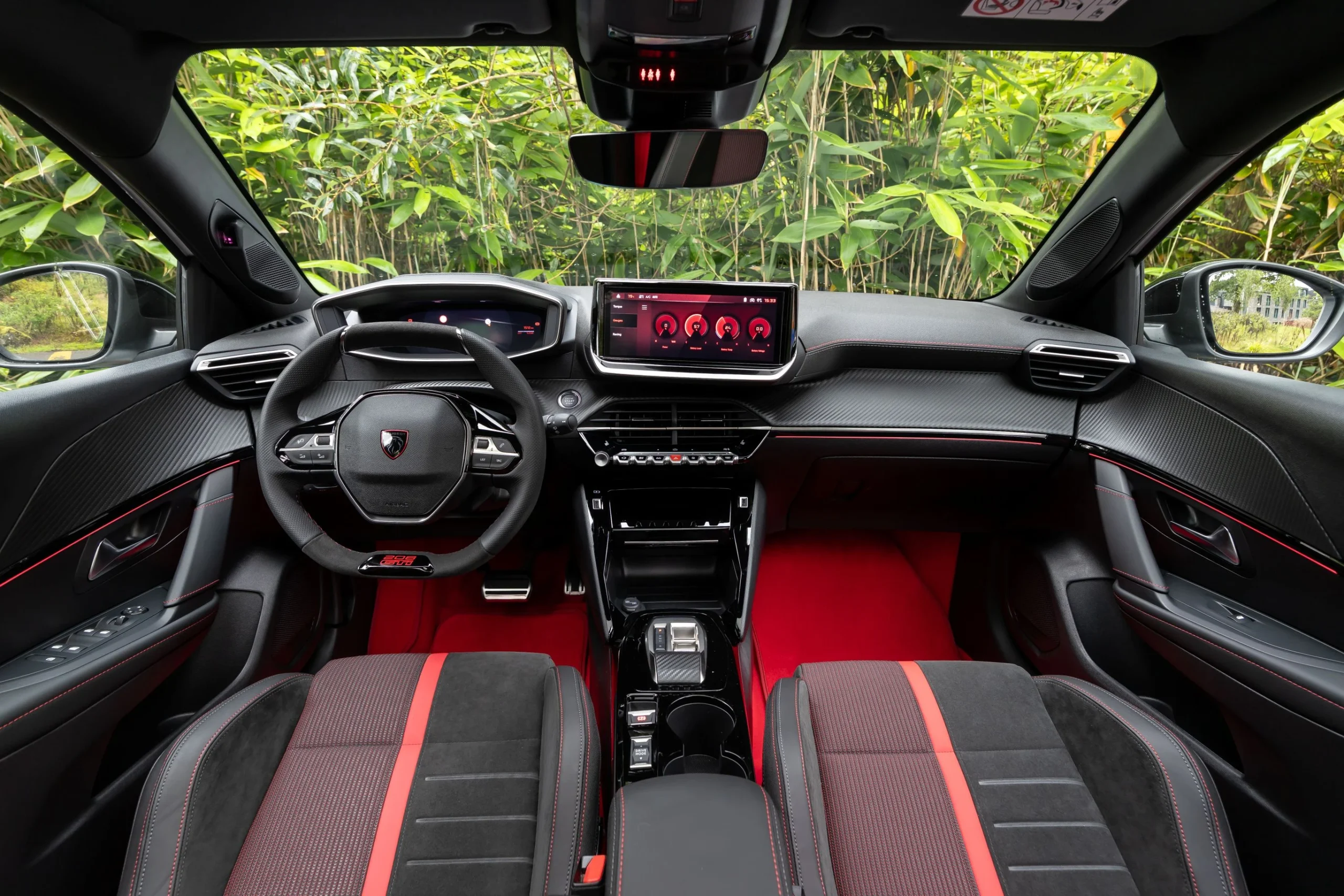 Interiér Peugeotu E-208 GTi s červenými koberci a sportovním volantem