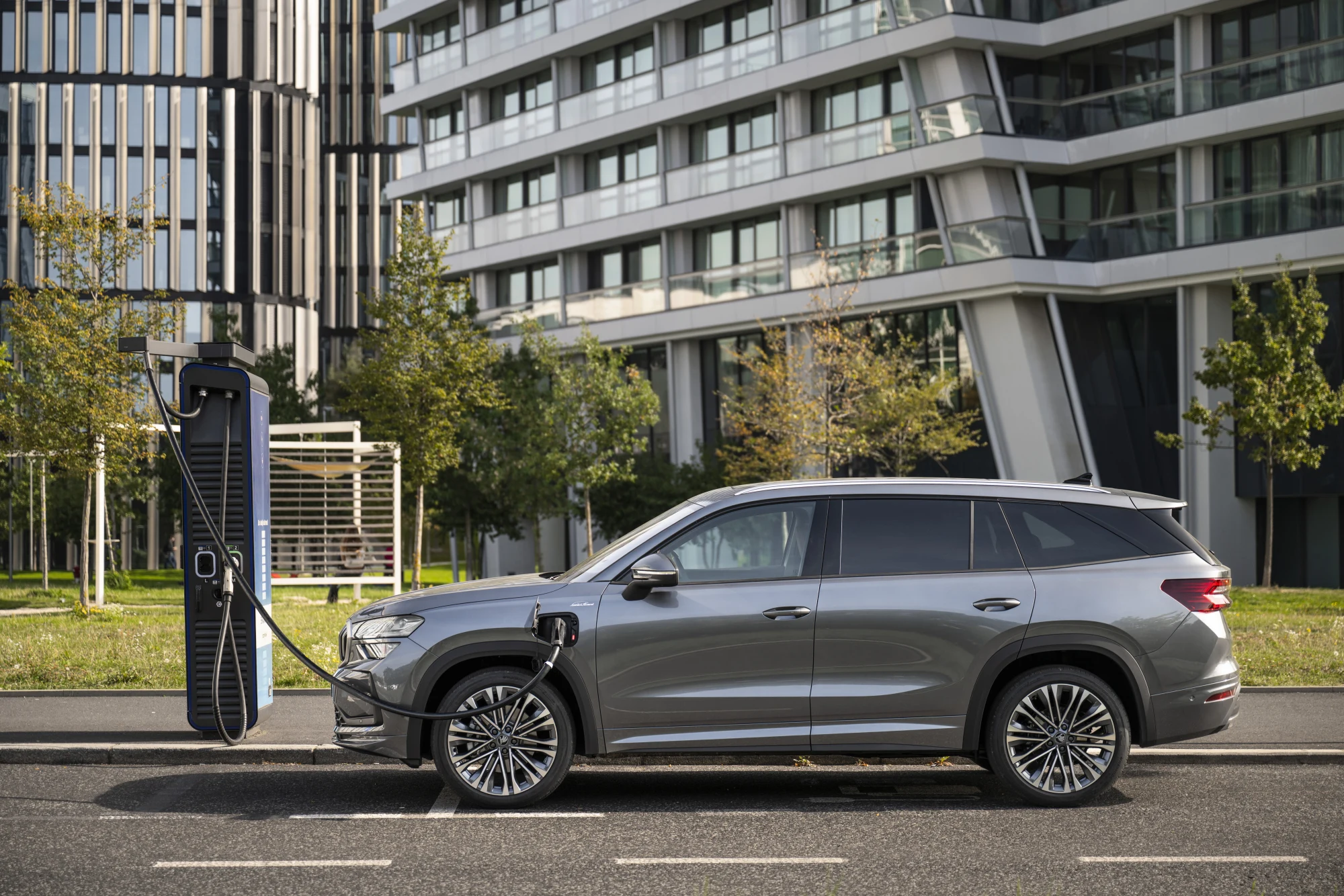 Šedá Škoda Kodiaq Laurin & Klement připojená k nabíjecí stanici