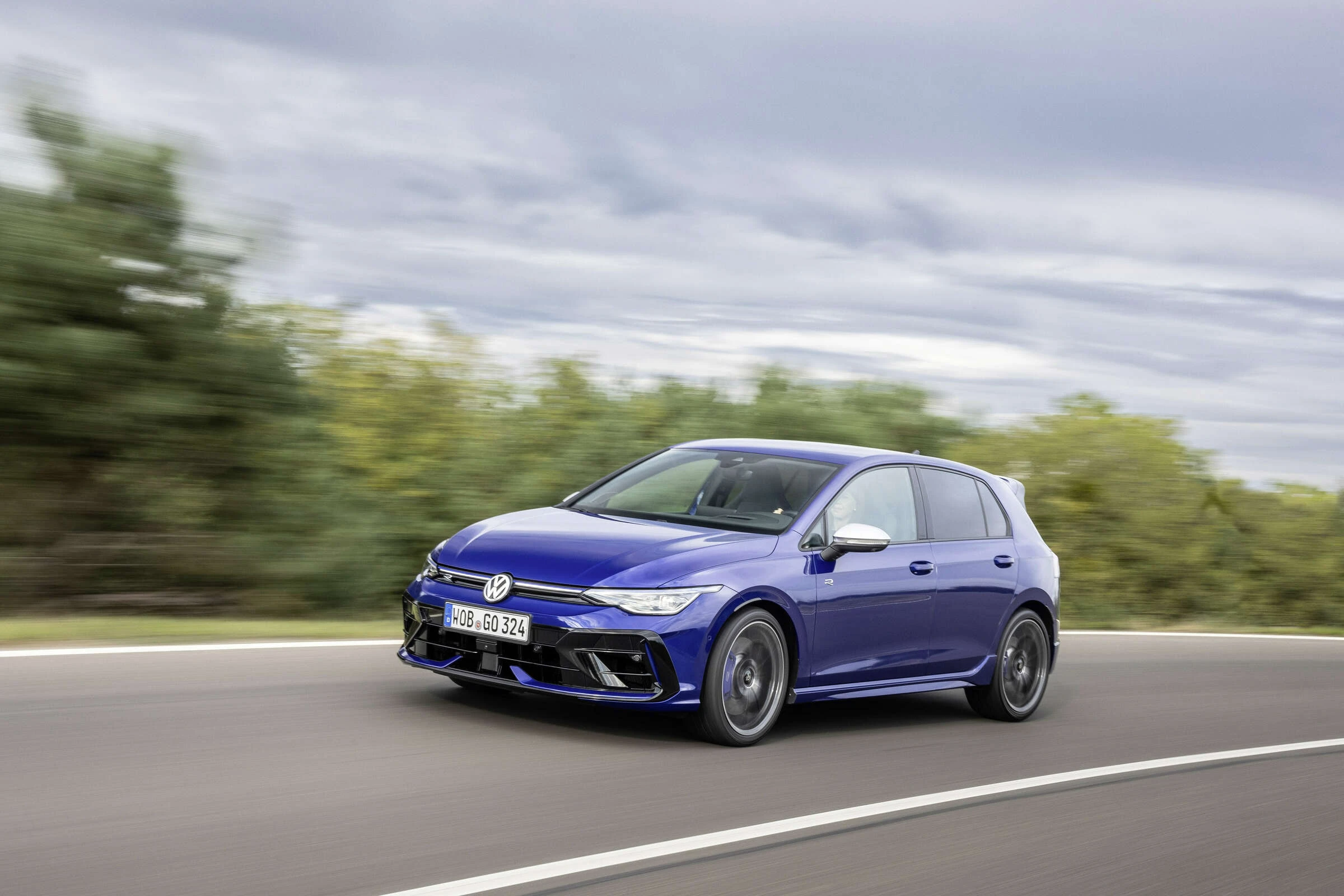 Modrý pětidveřový Volkswagen Golf R po modernizaci za jízdy
